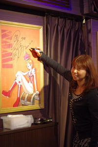 ナミのポスターにサインをする声優の岡村明美