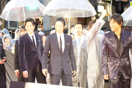 上映前に雨の振る中レッドカーペットに登場した出演者ら