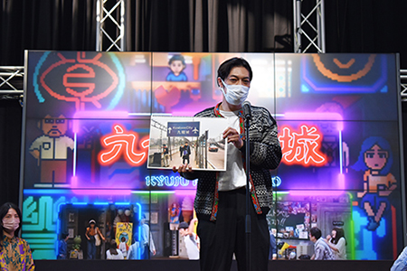 香港を訪れたときの写真を手に、香港の魅力を語る石田剛太