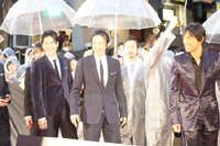 上映前に雨の振る中レッドカーペットに登場した出演者ら