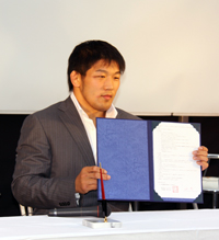 契約書にサインを済ませた石井慧