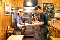 『究極のカレーAWARD』選考メンバーのハラ☆デリック氏(左)から総合グランプリの記念盾が手渡された。